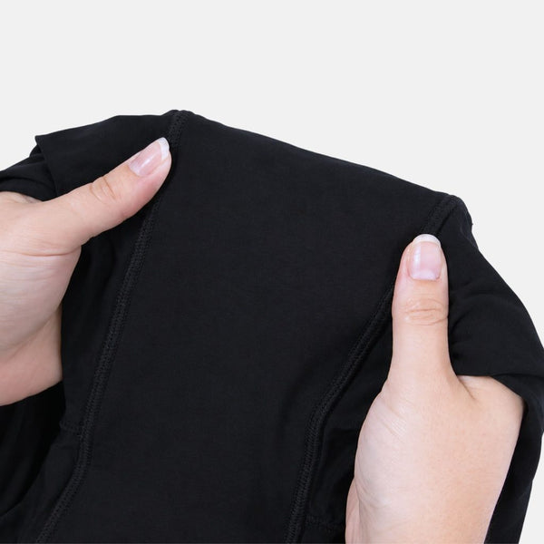 Hands holding open the gusset of the Her Bloom Shortie in black, showing the stitched absorbent panel