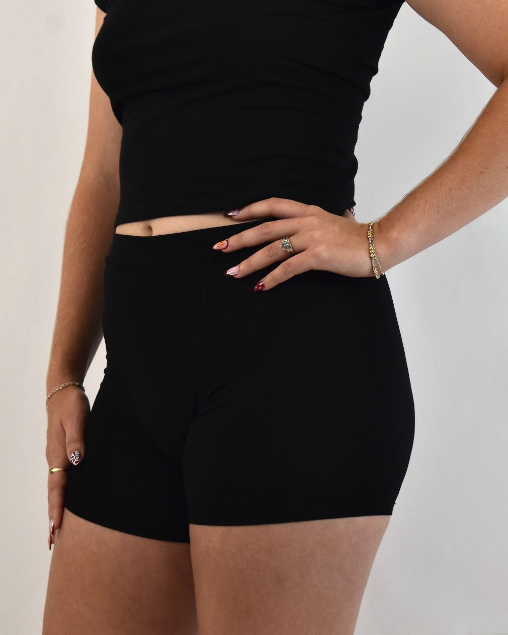 The Shortie in black, side view worn on model with a hand on the hip